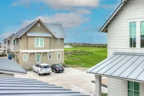 A residential area with houses, a golf course, and parked cars. - Palmilla Beach Resort-214 Sunset Avenue Casita 7 (Port Aransas)