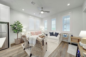A modern living room with a sofa, chairs, a dining area, and a kitchen. - Palmilla Beach Resort-214 Sunset Avenue Casita 7 (Port Aransas)