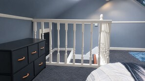 A room with a white crib, a black dresser with drawers, and a blue carpet. - Unique 2 Floor Apartment in Manchester. Private Cinema! (Manchester)