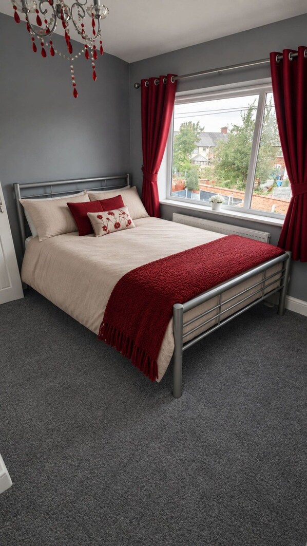 A bedroom with a bed, a window with curtains, a chandelier, and a view of the outside. - Unique 2 Floor Apartment in Manchester. Private Cinema! (Manchester)