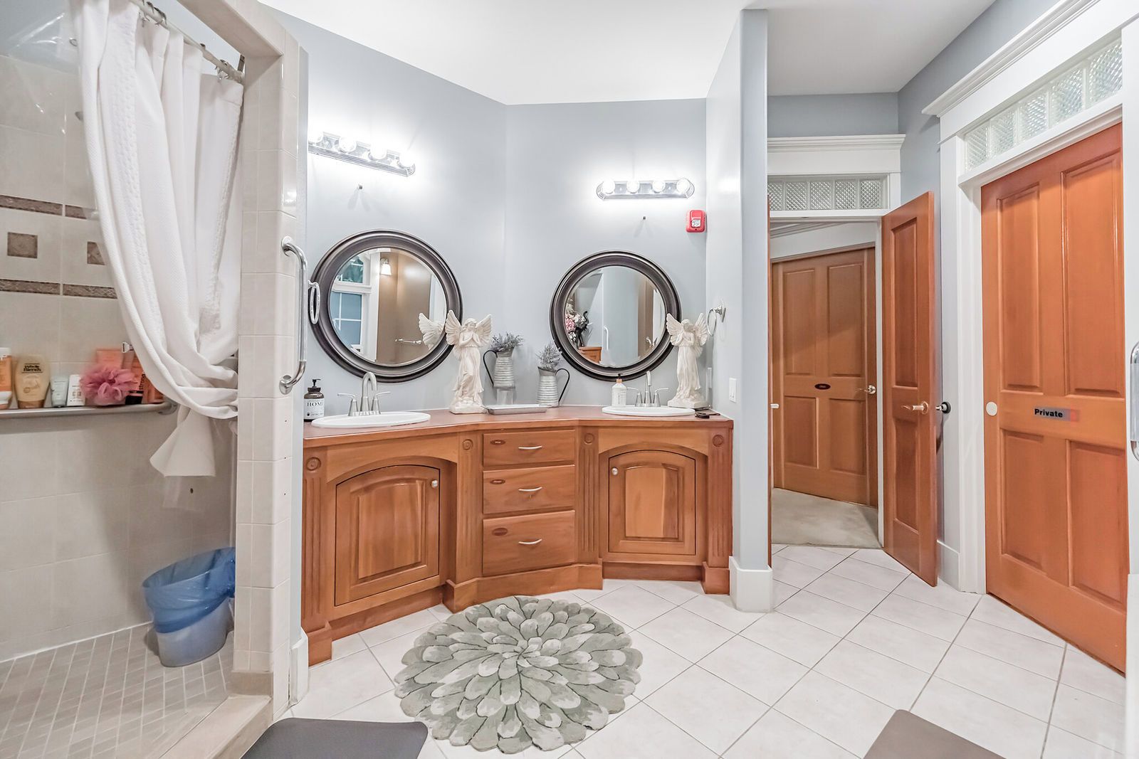 A bathroom with two sinks, vanity, and a shower area.