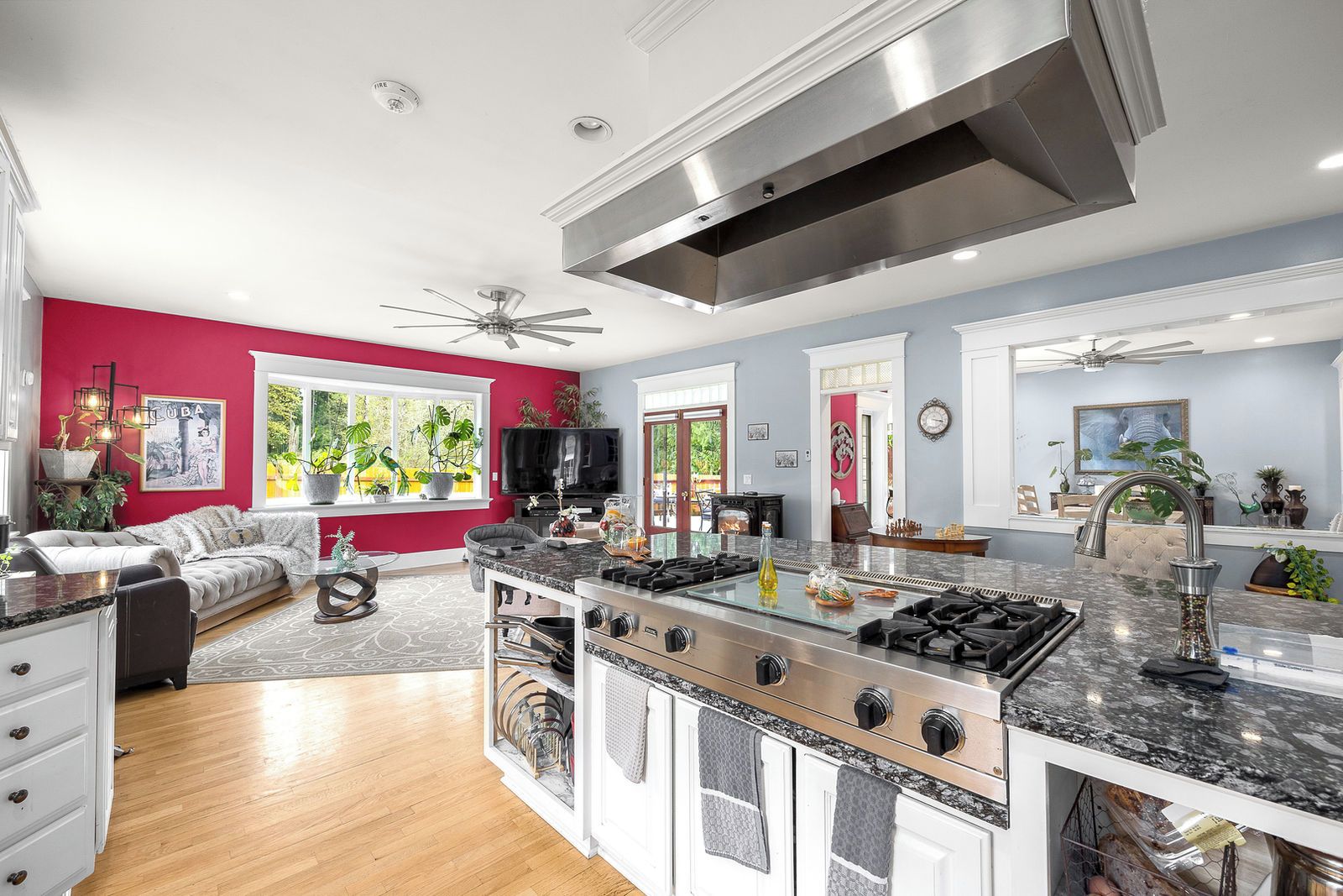 A modern kitchen with a central island, stainless steel appliances, and a ceiling fan.