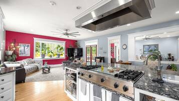 A modern kitchen with a central island, stainless steel appliances, and a ceiling fan.