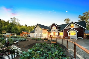 A residential property with a well-maintained garden, a fenced driveway, and a variety of plants.