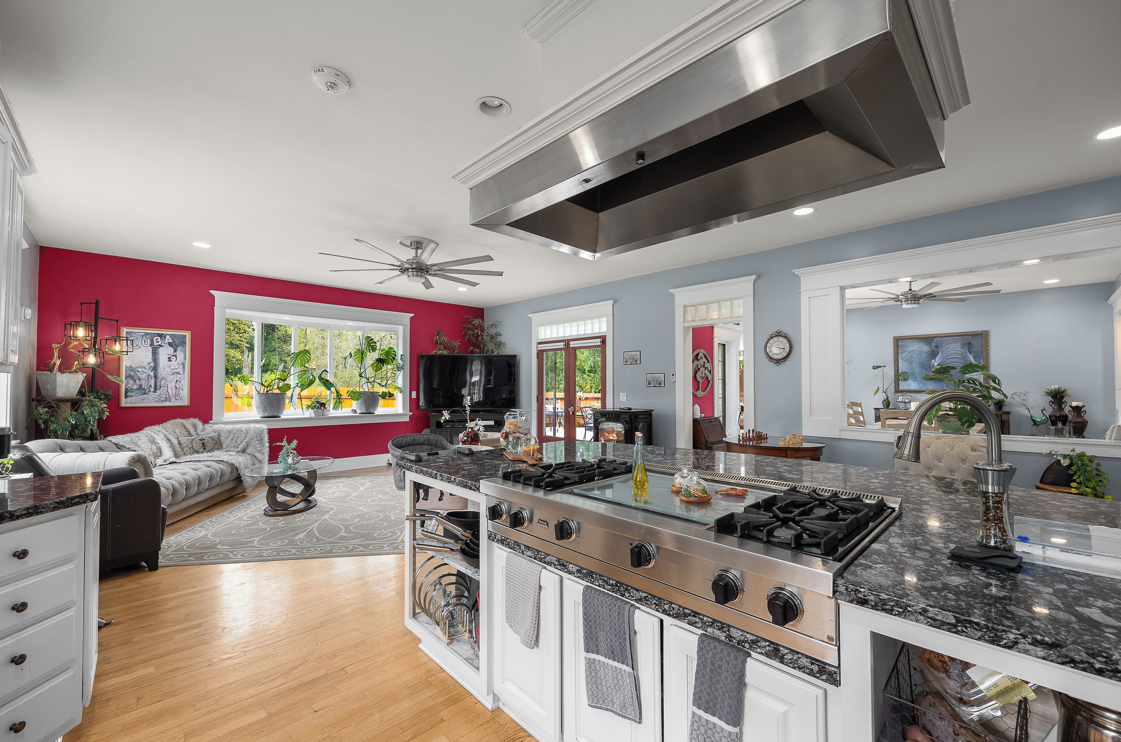 A spacious kitchen with a large island, modern appliances, and a red accent wall.