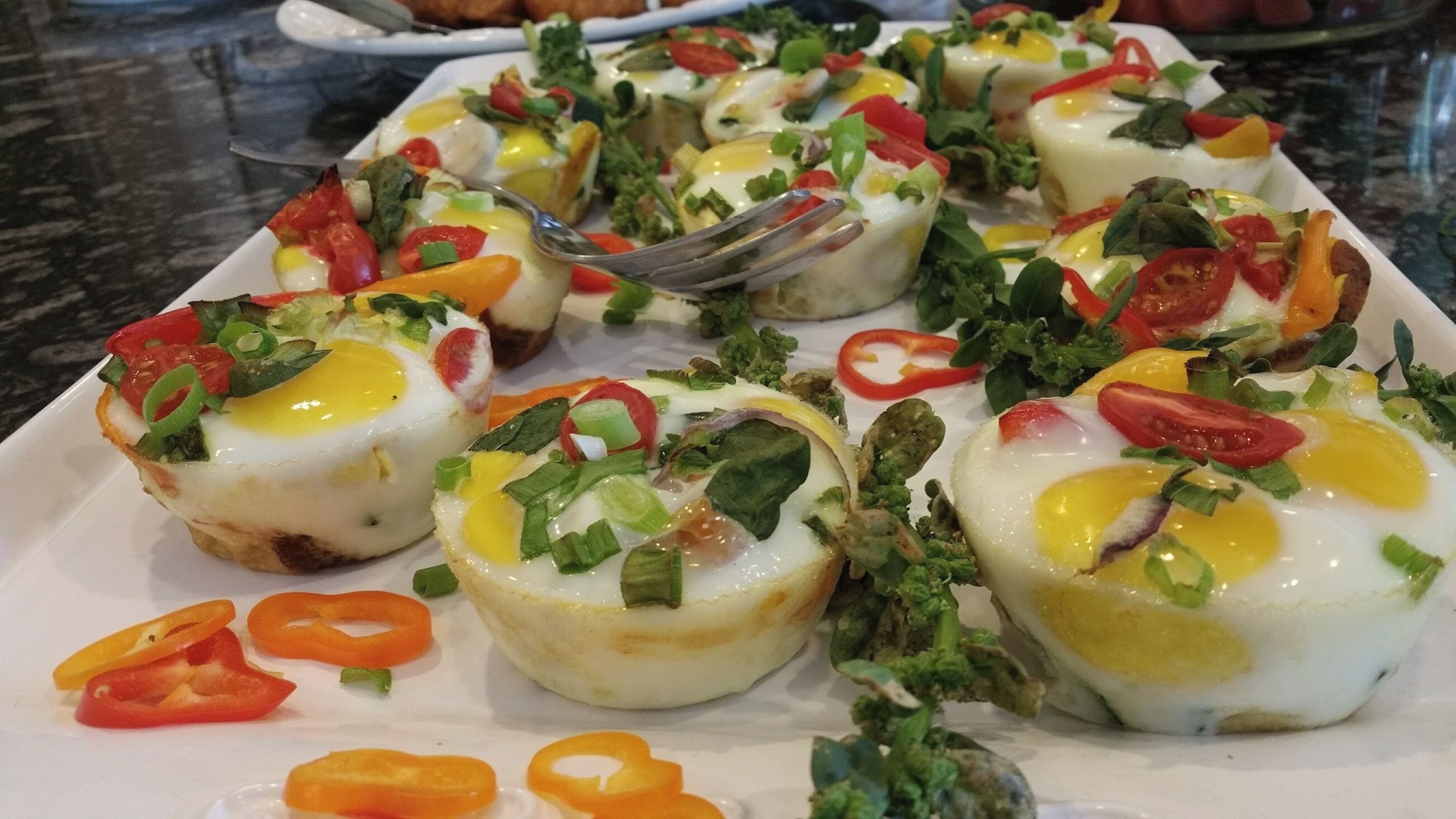 A plate of food with eggs, vegetables, and a fork.