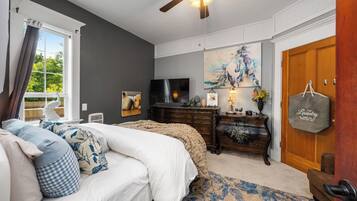 A bedroom with a bed, dresser, and a television.