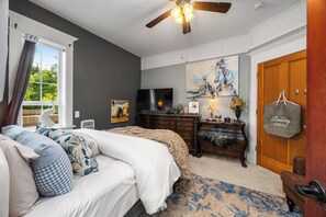 Un dormitorio con cama, cómoda y televisor.