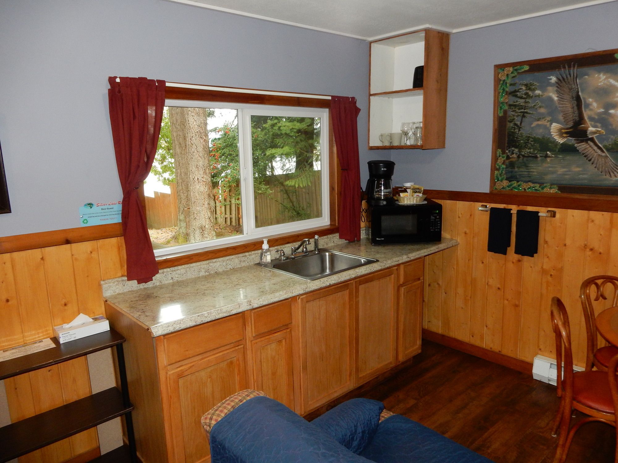 A compact kitchen with a sink, a coffee maker, and a microwave.
