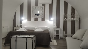 A hotel room with a bed, a wardrobe, a mirror, and a suitcase. - Comeacasa B&B (Palo del Colle)