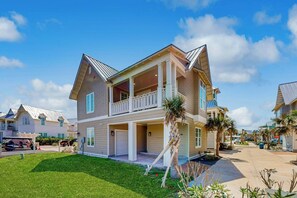 Ein zweistöckiges Wohnhaus mit Veranda, Garage und einem gepflegten Rasen.