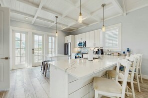 A spacious kitchen with white cabinetry, a large island, and pendant lighting. - Palmilla Beach Resort-102 Agave Lane (Port Aransas)