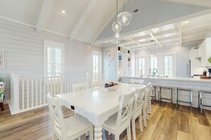 A spacious kitchen with a central island, white cabinetry, and a large window providing natural light. - Palmilla Beach Resort-104 Agave Lane (Port Aransas)