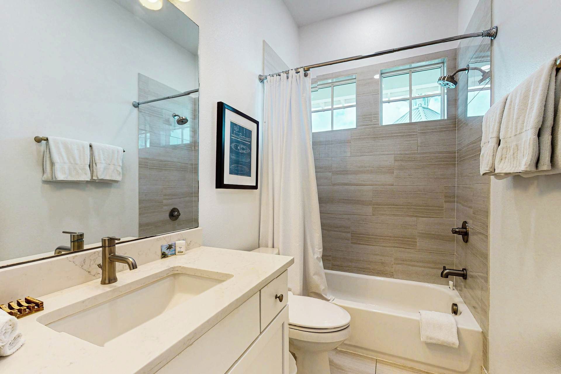 A bathroom with a double sink, a toilet, a bathtub, and a shower.