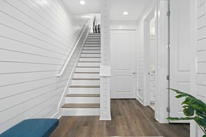 A staircase with white walls and wooden steps leading to a door. - Palmilla Beach Resort-119 Wild Indigo Street (Port Aransas)