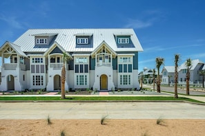 A large, multi-story house with a symmetrical facade, multiple windows, and a central entrance. - Palmilla Beach Resort-119 Wild Indigo Street (Port Aransas)