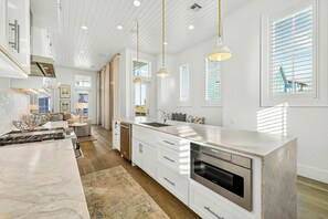A modern kitchen with a large island, stainless steel appliances, and pendant lighting. - Palmilla Beach Resort-120 Cattail Street (Port Aransas)