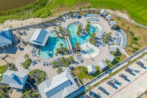 An aerial view of a resort with multiple swimming pools, sun loungers, and a parking area. - Palmilla Beach Resort-122 Wild Indigo Street (Port Aransas)