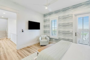 A bedroom with a bed, a chair, a television, and a window with blinds. - Palmilla Beach Resort-128 Cattail Lane (Port Aransas)