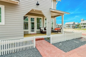 A coastal house with a covered porch, a white picket fence, and a gravel pathway. - Palmilla Beach Resort-130 Sweetbay Street (Port Aransas)