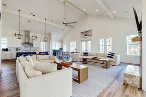 A spacious living area with a high ceiling, a dining area, and a kitchen. - Palmilla Beach Resort-133 Sunrise Avenue (Port Aransas)