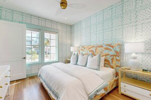 A bedroom with a bed, bedside tables, a window, and a ceiling fan. - Palmilla Beach Resort-135 Wild Indigo Street (Port Aransas)