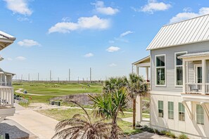 Ein Wohngebiet mit Blick auf einen Golfplatz, ein Haus mit Balkon und einem klaren Himmel.