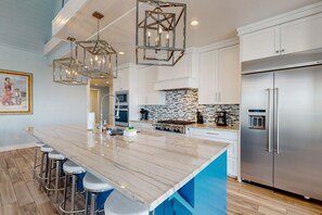 A modern kitchen with a marble island, stainless steel appliances, and pendant lighting. - Palmilla Beach Resort-144 Sunrise Avenue (Port Aransas)
