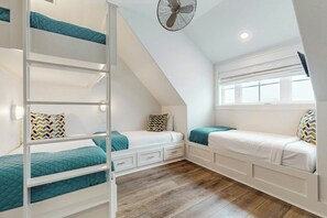 A dormitory room with bunk beds, a ceiling fan, and a window with blinds. - Palmilla Beach Resort-146 Sabal Lane (Port Aransas)