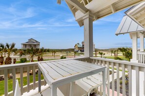 A wooden deck with a view of a beach and buildings. - Palmilla Beach Resort-146 Sabal Lane (Port Aransas)