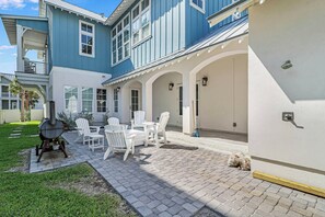 Eine Terrasse mit Sitzgelegenheit und Grill.