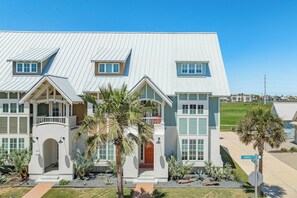 A two-story house with a flat roof, a front porch, and a driveway. - Palmilla Beach Resort-158 Sunset Avenue (Port Aransas)