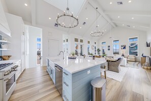 A spacious kitchen with a large island, modern appliances, and pendant lighting. - Palmilla Beach Resort-161 Sunrise Avenue (Port Aransas)