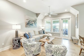 A living room with a sofa, armchairs, a coffee table, a floor lamp, and a ceiling fan. - Palmilla Beach Resort-162 Sunset Avenue (Port Aransas)