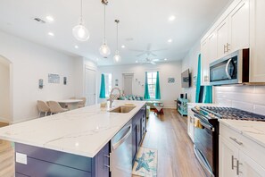 A modern kitchen with a central island, built-in appliances, and pendant lighting. - Palmilla Beach Resort-169 Spanish Dagger Lane (Port Aransas)