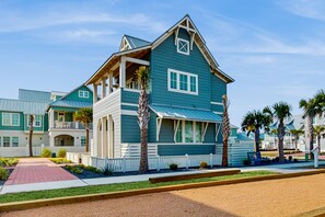 A two-story house with a balcony, a porch, and a red walkway leading to the entrance. - Palmilla Beach Resort-173 Spanish Dagger Lane (Port Aransas)