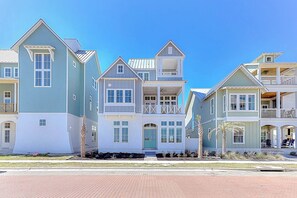 A row of coastal-style houses with multiple stories, balconies, and a clear sky. - Palmilla Beach Resort-173 Sunrise Avenue (Port Aransas)