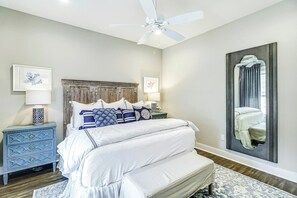 A bedroom with a bed, a nightstand, a dresser, a ceiling fan, and a large mirror. - Palmilla Beach Resort-177 Sunset Avenue (Port Aransas)