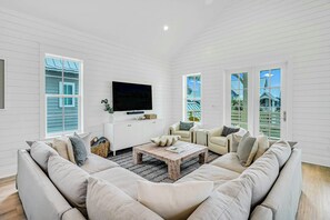 A living room with a sectional sofa, a coffee table, and a flat-screen TV mounted on the wall. - Palmilla Beach Resort-184 Sunset Avenue (Port Aransas)