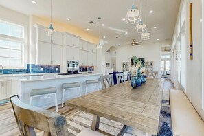 A spacious kitchen with white cabinets, a large island, and pendant lighting. - Palmilla Beach Resort-186 Sunrise Avenue (Port Aransas)