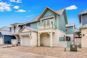 A residential building with a garage, a covered porch, and a small balcony. - Palmilla Beach Resort-187 Stargrass Lane (Port Aransas)