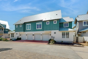 Ein zweistöckiges Wohnhaus mit Garage, einer roten Veranda und einem Metalldach.