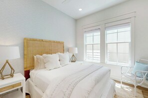 A hotel room with a large bed, two bedside tables, a chair, and a window with blinds. - Palmilla Beach Resort-218 Sunrise Avenue (Port Aransas)