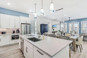 A modern kitchen with white cabinetry, a central island, and pendant lighting. - Palmilla Beach Resort-224 Sunrise Avenue (Port Aransas)