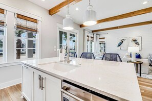A modern kitchen with a large island, stainless steel appliances, and a view of the outdoors. - Palmilla Beach Resort-225 Sunrise Avenue (Port Aransas)