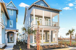 A two-story house with a balcony, a front porch, and a garage. - Palmilla Beach Resort-228 Sunrise Avenue (Port Aransas)