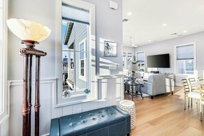 A modern living room with a large window, a flat-screen TV, and a blue sofa. - Palmilla Beach Resort-228 Sunrise Avenue (Port Aransas)