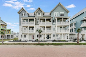 A multi-story residential building with a symmetrical facade, multiple balconies, and a front entrance. - Palmilla Beach Resort-244 Sunrise Avenue (Port Aransas)