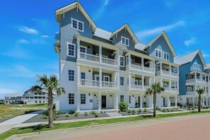 A multi-story residential building with balconies and a well-maintained lawn. - Palmilla Beach Resort-248 Sunrise Avenue (Port Aransas)