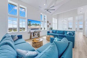 A spacious living room with a large sofa set, a coffee table, and a television mounted on the wall. - Palmilla Beach Resort-250 Sunset Avenue (Port Aransas)